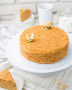 Delicious honey cake topped with bee decorations, perfect dessert for a sweet indulgence.